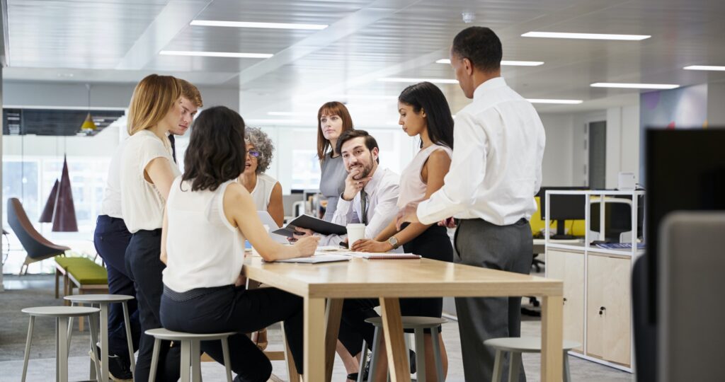 Business group brainstorming in open plan office, close up